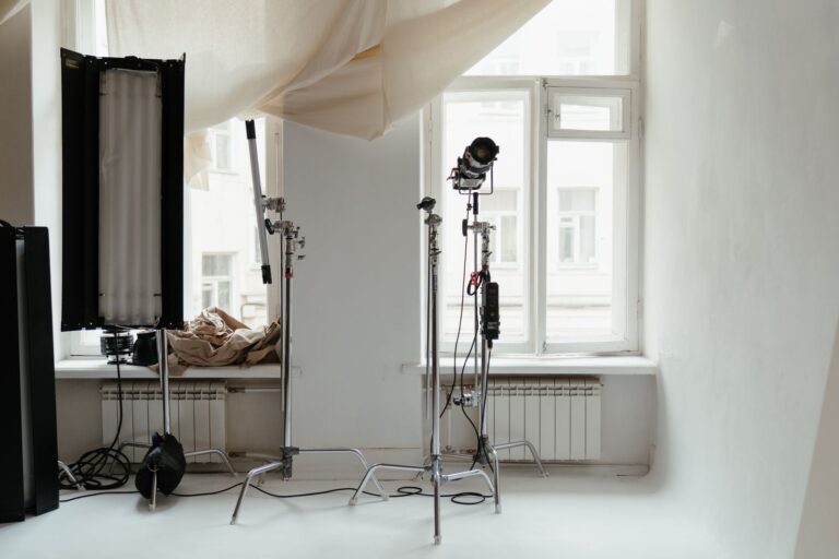 Studio lights and stands beside a window in an empty photography studio
